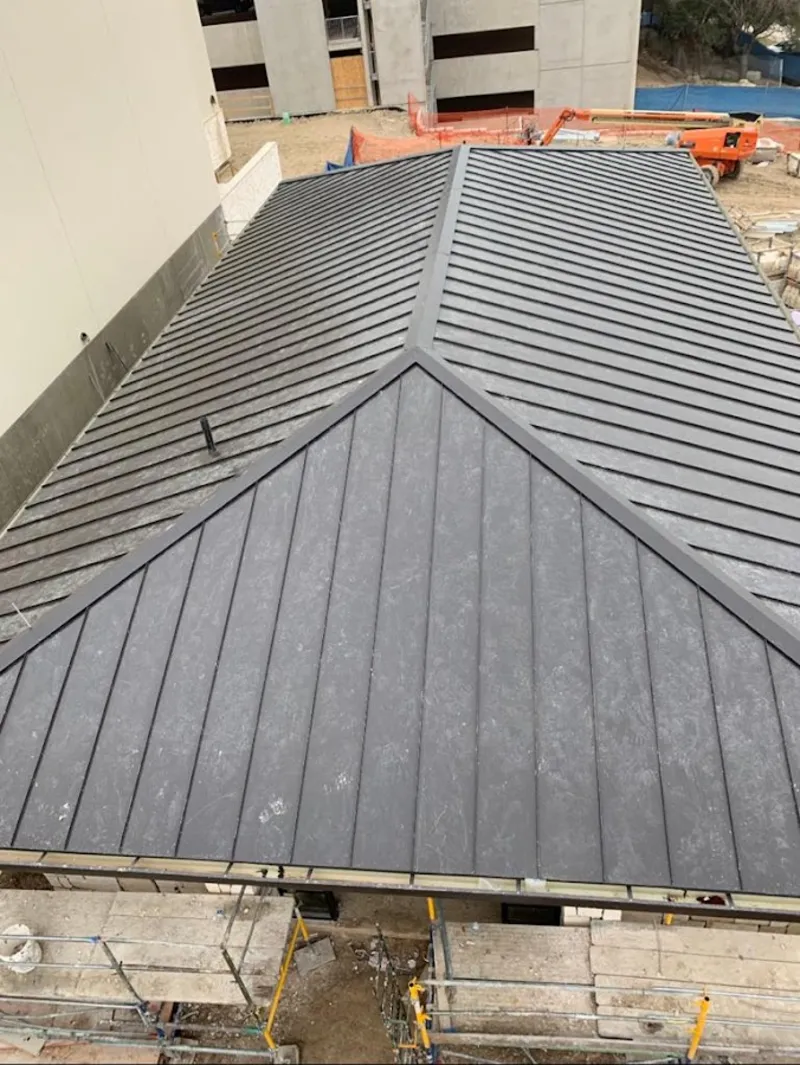 Commercial metal roof construction with crane equipment in Buenaventura Lakes