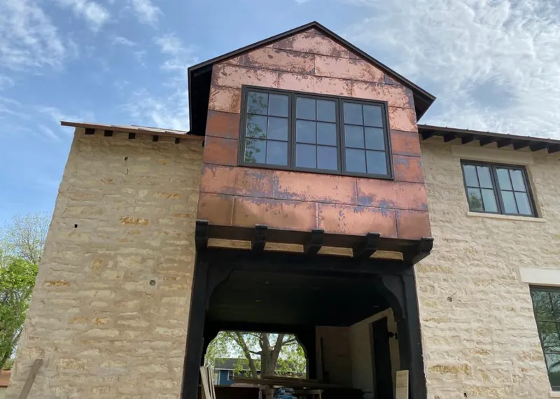 Copper metal panel facade on a stone building for Skylight Installation in Buenaventura Lakes